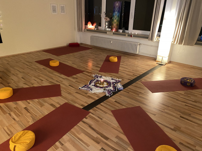 lichtdurchfluteter Yogaraum mit Yogamatten und Yogakissen mit hochwertigem Holzboden